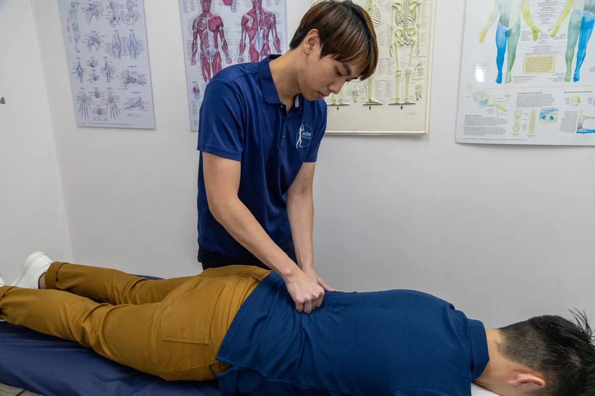 Physiotherapist treating a patient’s lower back at Activ Therapy