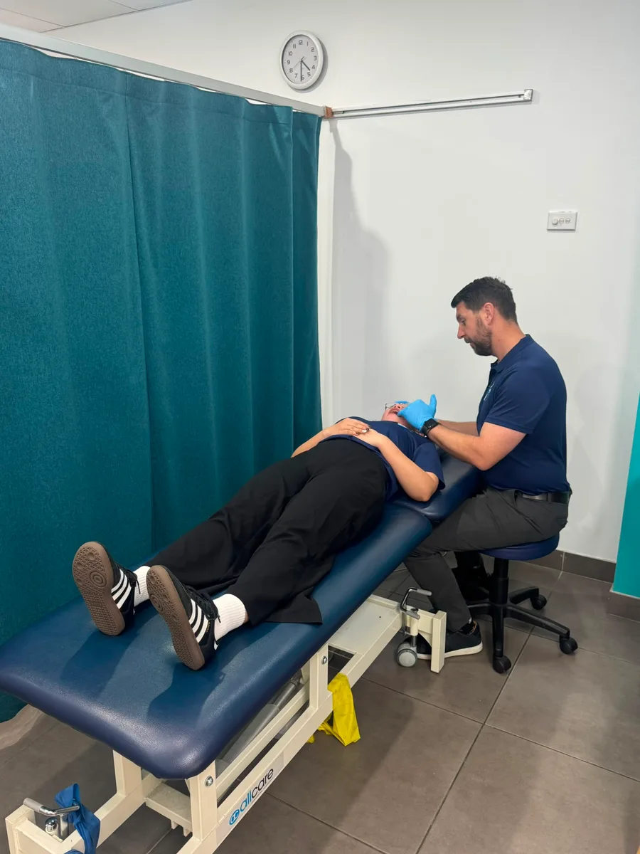 Physiotherapist treating a patient’s jaw muscles during a TMJ physiotherapy session